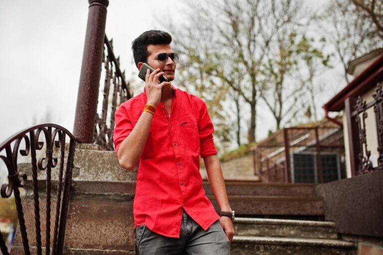 indian-man-red-shirt-sunglasses-posed-outdoor-speaking-phone_627829-2312